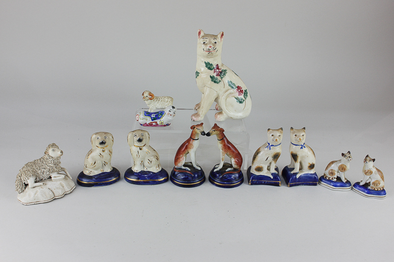 A collection of Staffordshire pottery animals comprising two pairs of cats, a pair of greyhounds,