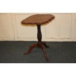 A mahogany oval shaped side table, with a serpentine border, on later carved baluster stem and