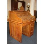 An oak roll top desk, tambour top enclosing an interior of drawers and pigeon holes, above
