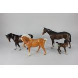 Four Beswick porcelain models of horses, head tucked with leg up (1549) in chestnut gloss, a mare (