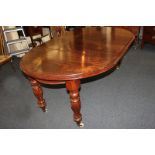 A Victorian mahogany extending dining table, with shaped oval top, on fluted baluster legs and