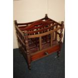 A mahogany Canterbury magazine rack, with four divisions and drawer, on turned legs, 43cm