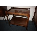 A mahogany two-tier tea trolley, with shaped gallery top, on chamfered supports on wheels, 76cm