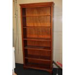 A yew wood reproduction open bookcase, with dentil cornice and five shelves, on bracket base, 88cm