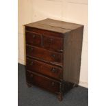 A rustic oak chest of two short over three long drawers, with brass ring handles, on ball feet,