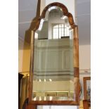 A Queen Anne style walnut framed wall mirror with bevelled glass, mirror plate, 66cm by 27.5cm