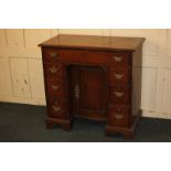 A George III oak kneehole desk, with rectangular top above an arrangement of seven drawers, and