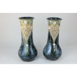 A pair of Royal Doulton glazed stoneware vases, of slender form with flared neck with impressed gilt