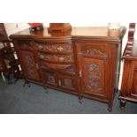 A Victorian style mahogany carved sideboard, the rectangular top with central bowfront, and an
