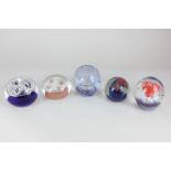 A collection of five glass paperweights with swirling polychrome and bubble decoration, to include a