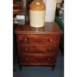 A small Victorian chest of three drawers, top with moulded edge, knob handles, on stepped based with