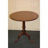 A George III mahogany circular side table, with tilt top on carved pedestal stem and tripod base,