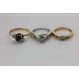 A diamond ring rubover set and with two stones to each shoulder in 18 carat yellow and white gold, a