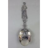 A large imported Victorian silver marriage spoon, the figural handle of a women holding a flower,