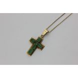 An emerald cross pendant claw set with six step cut stone in unmarked yellow gold on an 18 carat