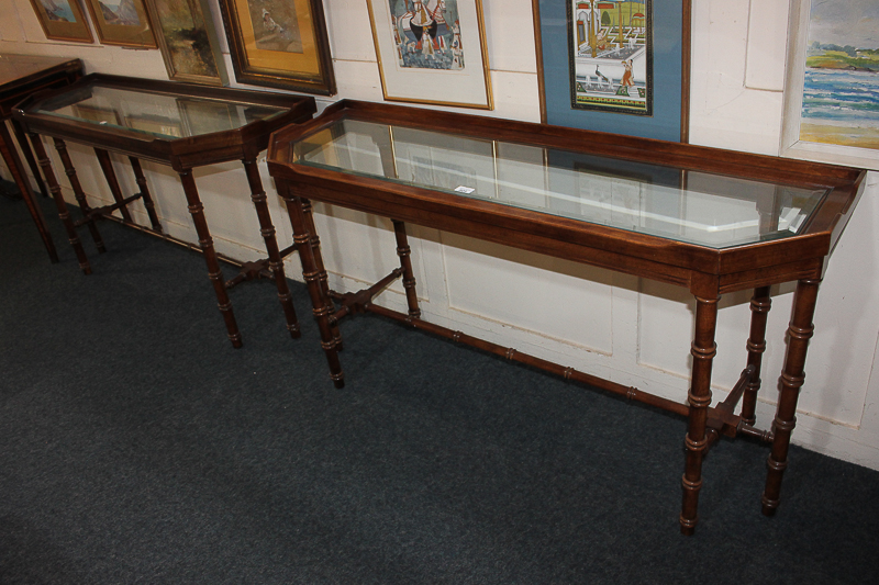 A pair of mahogany glass-topped console tables, rectangular shape with cut corners and shaped