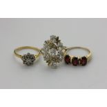 A 9ct yellow gold and cubic zirconia cluster ring, a 14 carat yellow gold and garnet ring, a diamond