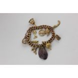 A 9ct gold curb link bracelet hung with various charms (various carats), 35g gross