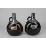 A metal mounted amber glass flask and another similar (with damaged spout), with labels for whisky