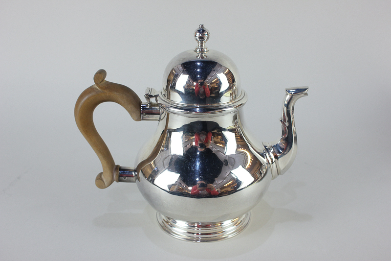 An Elizabeth II silver Queen Anne style teapot, makers Wakely & Wheeler, London 1967, with wooden