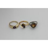 A sapphire two-stone crossover ring, an amethyst ring in 14ct gold, and a citrine ring in silver and