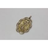 A Chinese gold pendant carved with Chinese characters, the reverse engraved, 6.1g