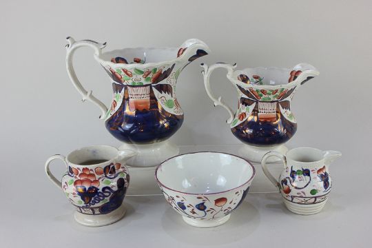 Two porcelain jugs of graduated size, decorated in the Imari palette, together with two smaller jugs