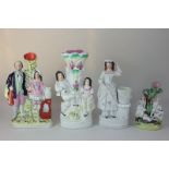 A collection of four Staffordshire pottery flat back spill vases, modelled as figures including a