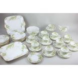 A Wedgwood Etruria porcelain part tea service with green floral decoration on white ground, with