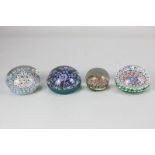 Four various coloured millefiori glass paperweights including one inscribed 'Mildred'