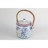 A Poole pottery biscuit barrel and cover, with wicker handle, decorated with flowers