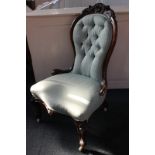 A Victorian walnut framed spoon back nursing chair with carved scrolling foliate design and