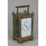A brass carriage clock, the case with fluted pillars, lattice and floral borders, the enamelled dial