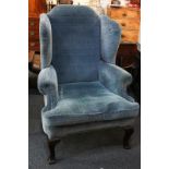 A wing back armchair with chequered blue upholstery, on cabriole front legs