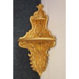 A Rococo style carved and gilded wood corner shelf, 34cm wide