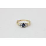 A sapphire and diamond ring, the oval cut stone with a trefoil of brilliant cuts to each shoulder