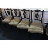 A set of four Victorian dining chairs with inlaid vase splats and upholstered seats, on turned legs