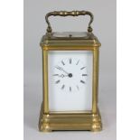 A French brass repeater carriage clock with white enamel dial and Roman numerals, movement