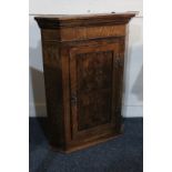 A small oak hanging corner wall cupboard with single panel door enclosing two shelves, 55cm wide