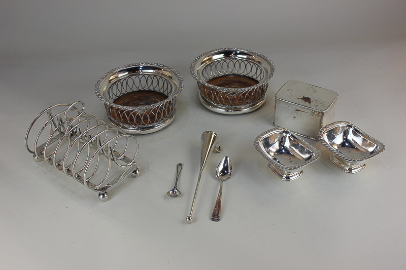 A pair of silver plated bottle coasters, a six-division toast rack, a pair of salts, a candle