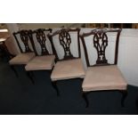 A set of four mahogany Chippendale style dining chairs with scrolling vase splats and upholstered