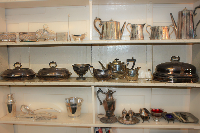 A pair of silver plated oval tureens with clear glass liners, a cloche, a sugar basket with glass