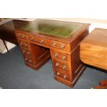 A Victorian mahogany pedestal desk with green and gilt leather inset top above an arrangement of