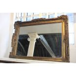 A giltwood and gesso rectangular wall mirror with scrolling foliate decorated frame, 99cm by 74cm