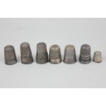 A collection of seven silver and white metal thimbles