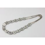 A Chinese silver and mother of pearl necklace strung with fourteen discs, each applied with a
