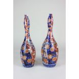 A pair of Japanese Imari porcelain vases of slender gourd shaped form decorated with curving borders