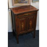 A Victorian rosewood music cabinet, inlaid with urns and instruments, the two-panel door enclosing