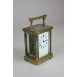 A brass cased carriage clock, the white enamel dial with Roman numerals, the movement stamped '