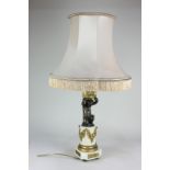 A French alabaster and gilt metal mounted table lamp with bronze putti holding aloft an urn, on a